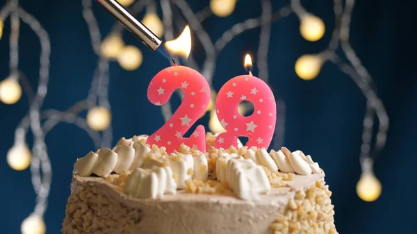 Tarta de cumpleaños con vela de 29 números en el fondo azul prendida fuego por el encendedor. Vista de primer plano — Foto de Stock