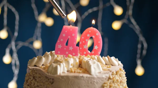 Birthday cake with 40 number candle on blue backgraund set on fire by lighter. Close-up view — Stock Photo, Image