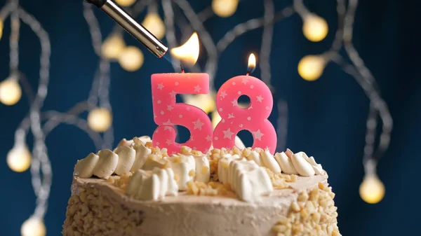 ライトによって火にセットされた青の背景に58番号のろうそくと誕生日ケーキ。クローズアップビュー — ストック写真