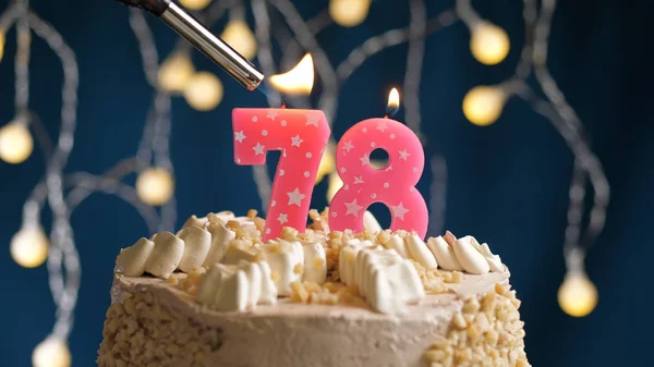 Pastel de cumpleaños con 78 número de vela en el fondo azul incendiado por el encendedor. Vista de primer plano —  Fotos de Stock