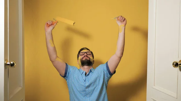 Der Mensch freut sich, dass das Streichen der Wände abgeschlossen ist. Wohnungsrenovierung, Wandbemalung, abgeschlossenes Konzept. mittlerer Schuss — Stockfoto