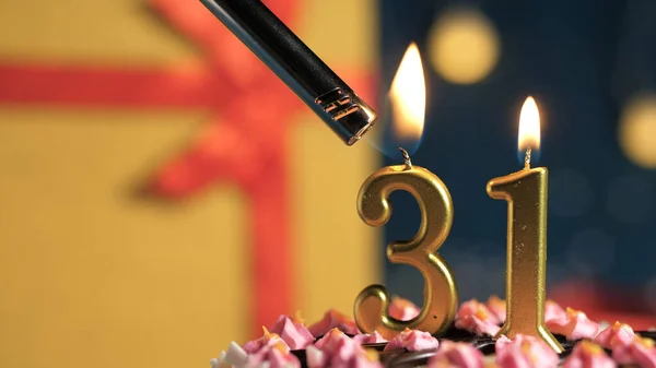 Tort de ziua de naștere numărul 31 de lumânări aurii care ard de brichetă, cadou de fundal cutie galbenă legată cu panglică roșie. Close-up — Fotografie, imagine de stoc