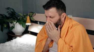 Adam burnunu siliyor. Çekici beyaz adam burnunu mendile sümkürdü. Soğuk algınlığı, grip, akut solunum hastalığı konsepti. Görüntüyü kapat