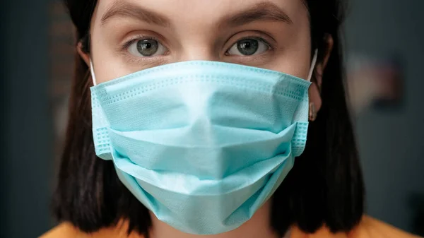 Girl in respiratory mask. Masked attractive woman looks at camera. Cold, flu, virus, tonsillitis, acute respiratory disease, quarantine, epidemic concept. Close-up