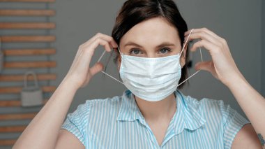 Çekici kız yüzüne cerrahi maske takıyor. Grip, grip, virüs, akut solunum enfeksiyonları, karantina, salgın, ironi, iğneleme konsepti. Görüntüyü kapat