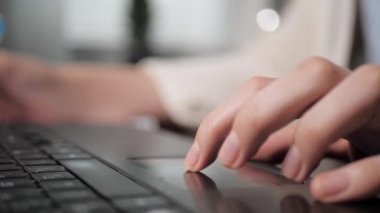 Sol kadın eli dizüstü bilgisayarın dokunmatik dokunmatik dokunmatik dokunmatik tuşuna basıyor. İşteki ya da öğrenim gören bir kız. Yakın plan.