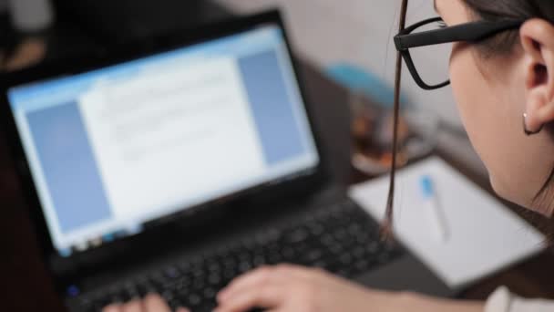 Suddig kvinnliga händer flicka med glasögon på natten skriva på laptop tangentbord, tittar på skärmen. Flicka frilansare på jobbet, studie, programmerare, kodare, hacker, kommunikation, sociala nätverk, skrivkoncept — Stockvideo