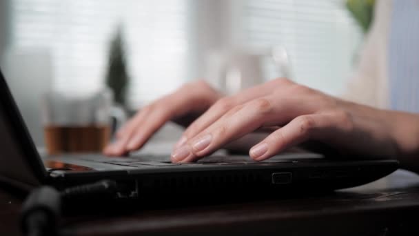 Las manos femeninas que escriben en el teclado del ordenador portátil, la mano derecha interrumpida levanta la taza con la taza de té baja, se reanuda el trabajo. Redes sociales, comunicación, freelance, estudio, hacker coder, estudiante, concepto de programador — Vídeos de Stock