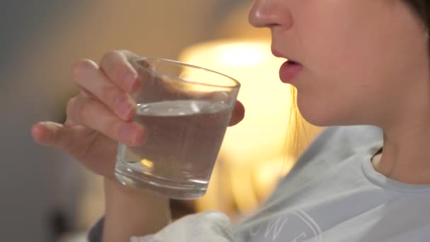 Chica bebe agua antes de ir a la cama de vidrio transparente antes de ir a la cama. Primer plano — Vídeos de Stock