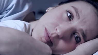 Kız gece ağlıyor. Kızgınlık, hayal kırıklığı, özel hayattaki sorunlar, ilişki kavramındaki sorunlar. Çekici genç bir kadın yatakta yatıyor ve gözyaşları yüzünden akıyor. Yakın plan.