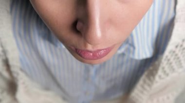 Kız öksürüyor ve ağzını peçeteyle örtüyor. Soğuk algınlığı, grip, gırtlak iltihabı, tüberküloz, astım, bronşit, alerji, zatürree, APF inhibitörleri, nazofaringeal sızıntı kavramları. Üst Manzara. Yakın plan.