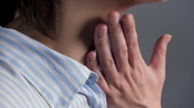 Kadın boğazına dokunur ve yutar. Boğaz ağrısı, bademcik iltihabı, gırtlak iltihabı, farenjit, enterovirüs enfeksiyonu, mononükleoz, adenovirüs enfeksiyonu, alerji konseptleri. Yan görüş. Yakın plan.