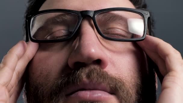 Fejfájás. Az ember csukott szemmel érinti a fejét. Migrén, vérnyomás, stressz, szemfáradtság. Lényegében. Közelkép — Stock videók