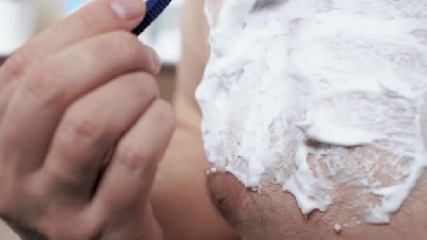 Man shaves his hairy chest with disposable shaving blade. Close-up — Stock Video