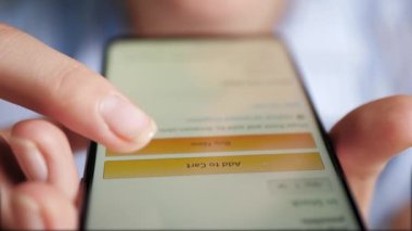 Kadın parmak klik tuşu Cart 'a ekle, kadın eli telefonu tutar. İnternetten alışveriş, online mağaza, kendini izole etme, karantina kavramları. Yakın plan.