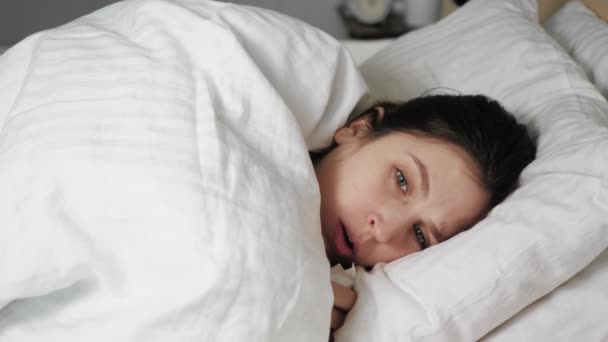 Женщина кашляет, белая женщина лежит в постели, покрытая салфеткой из одеяла. Простуда, грипп, ларингит, туберкулез, астма, коронавирус, бронхит, аллергия, пневмония концепции. Закрыть — стоковое видео