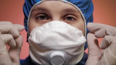 Koruyucu takım elbiseli kızın portresi yüzüne solunum maskesi ve güvenlik gözlüğü takıyor. Uyarı, salgın, salgın hastalık kontrolü, COVID-19, enfeksiyon kapma riski. Kapat.