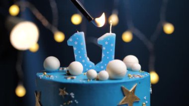 11 numaralı doğum günü pastası gökyüzü ve ay konsepti, mavi mum çakmak ateşidir ve sonra söner. Gerekirse ekranın sağ tarafına boşluk kopyala. Yakın çekim ve yavaş çekim