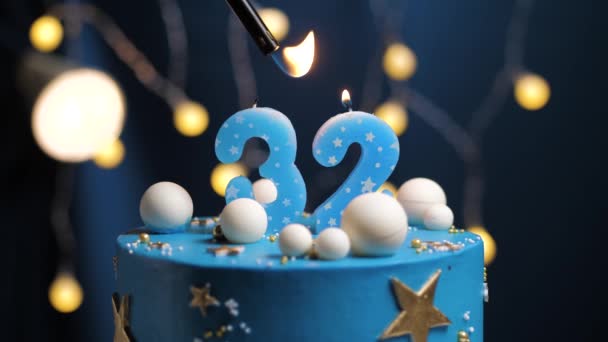 Torta de cumpleaños número 32 estrellas cielo y concepto de la luna, vela azul es fuego por encendedor y luego sopla. Copie el espacio en el lado derecho de la pantalla si es necesario. Primer plano y cámara lenta — Vídeos de Stock