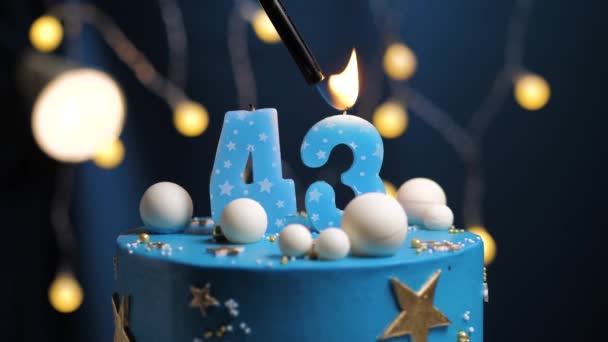 Pastel de cumpleaños número 43 estrellas cielo y concepto de la luna, vela azul es fuego por encendedor y luego sopla. Copie el espacio en el lado derecho de la pantalla si es necesario. Primer plano y cámara lenta — Vídeos de Stock