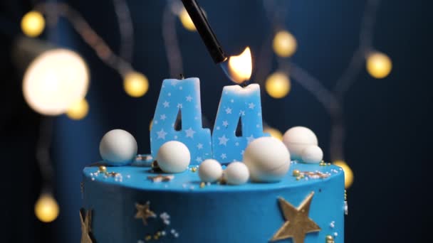 Torta de cumpleaños número 44 estrellas cielo y concepto de la luna, vela azul es fuego por encendedor y luego sopla. Copie el espacio en el lado derecho de la pantalla si es necesario. Primer plano y cámara lenta — Vídeos de Stock