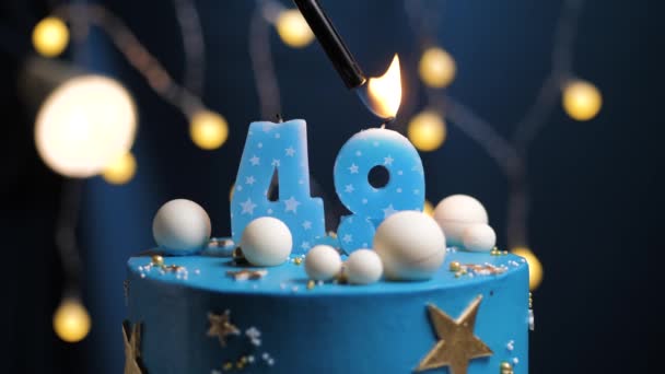 Bolo de aniversário número 49 estrelas céu e lua conceito, vela azul é fogo por isqueiro e depois sopra para fora. Copie o espaço no lado direito da tela, se necessário. Close-up e câmera lenta — Vídeo de Stock