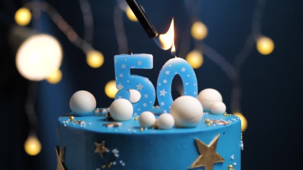 Pastel de cumpleaños número 50 estrellas cielo y concepto de la luna, vela azul es fuego por encendedor y luego sopla. Copie el espacio en el lado derecho de la pantalla si es necesario. Primer plano y cámara lenta — Vídeos de Stock