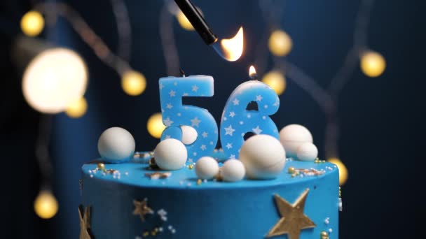 Pastel de cumpleaños número 56 estrellas cielo y concepto de la luna, vela azul es fuego por encendedor y luego sopla. Copie el espacio en el lado derecho de la pantalla si es necesario. Primer plano y cámara lenta — Vídeos de Stock