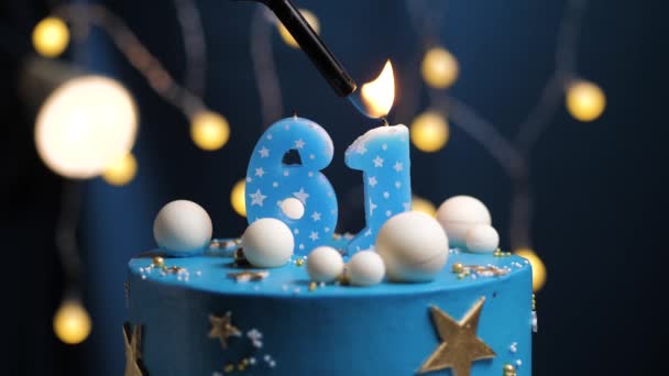 Narozeninový dort číslo 61 hvězdy nebe a měsíc koncept, modrá svíčka je oheň zapalovač a pak sfoukne. V případě potřeby zkopírujte mezeru na pravé straně obrazovky. Detailní záběr a zpomalení — Stock video