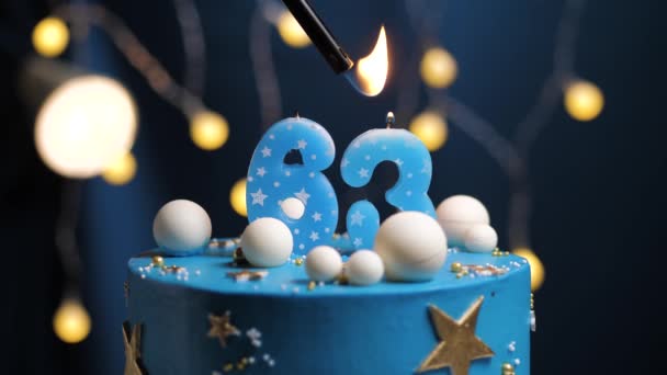 Narozeninový dort číslo 63 hvězdy nebe a měsíc koncept, modrá svíčka je oheň zapalovač a pak sfoukne. V případě potřeby zkopírujte mezeru na pravé straně obrazovky. Detailní záběr a zpomalení — Stock video