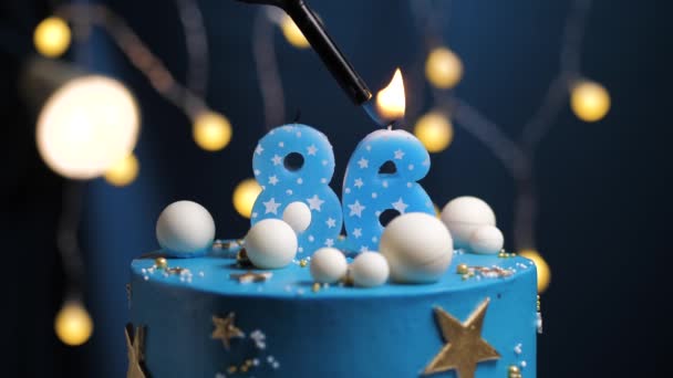 Születésnapi torta száma 86 csillag ég és hold koncepció, kék gyertya tűz öngyújtóval, majd elfújja. Másolja le a helyet a képernyő jobb oldalán, ha szükséges. Közelkép és lassított felvétel — Stock videók