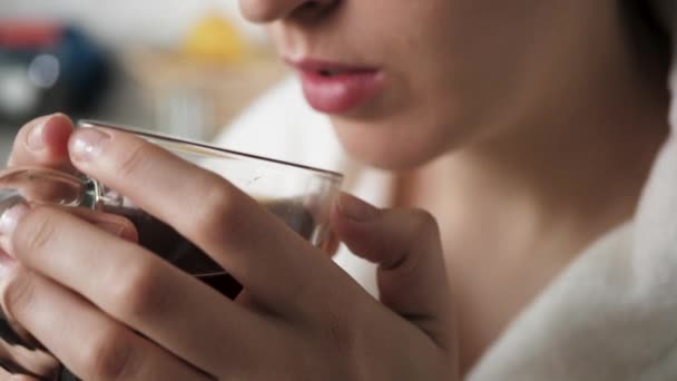 Meisje drinkt warme thee. Vrouwelijke handen brengen mok warme thee naar hun mond en drinken. Close-up — Stockvideo