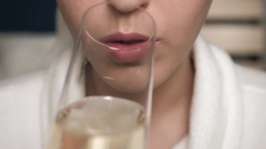 Çekici kadın şampanya içiyor. Kadın eli, yüzüne bir bardak şarap getirir ve içer. Yakın plan.