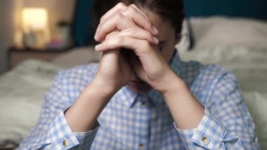 Kız dua ediyor. Genç bir kadın akşamları yatak odasında sırtüstü uzanmış dua ediyor. Yaklaşın ve yavaş çekim görünümü