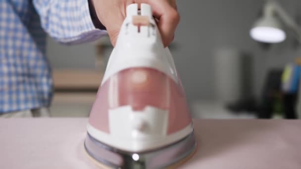 Niña planchando ropa. Las manos femeninas mueven hierro sobre ropa de cama rosa en la tabla de planchar en el apartamento — Vídeos de Stock