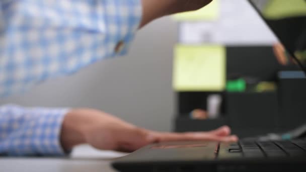 La mano femenina abre la cubierta del portátil en el lugar de trabajo, enciende el ordenador y comienza a escribir en el teclado — Vídeos de Stock