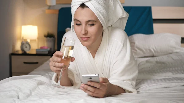Chica Bebiendo Vino Usando Teléfono Mujer Atractiva Dormitorio Albornoz Blanco —  Fotos de Stock