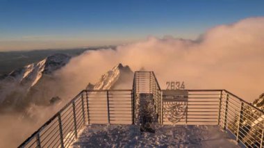 Dağ 'da 4K' lık bir zaman dilimi yüksek. Alçak Bulutlar Karlı Dağların Üzerinden Geçiyor.