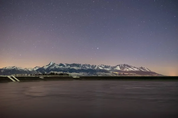 Water Tank Night Sky Snowy Mountains Background — 图库照片