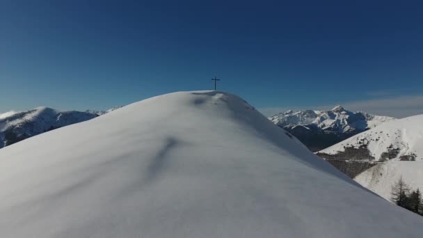 雪に覆われた山の上を宗教的な十字で飛ぶ素晴らしいドローンは — ストック動画