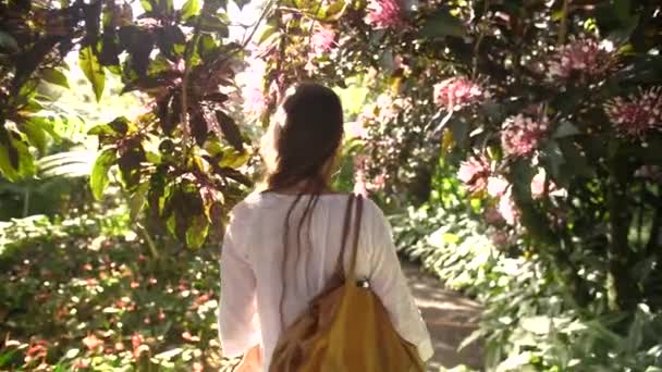 Siguiendo Una Hermosa Mujer Caminando Entre Árboles Tropicales Floreciendo Ubicación — Vídeo de stock