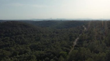 Çalılık arazideki yol. Arka planda Pic Saint Loup Dağı var.