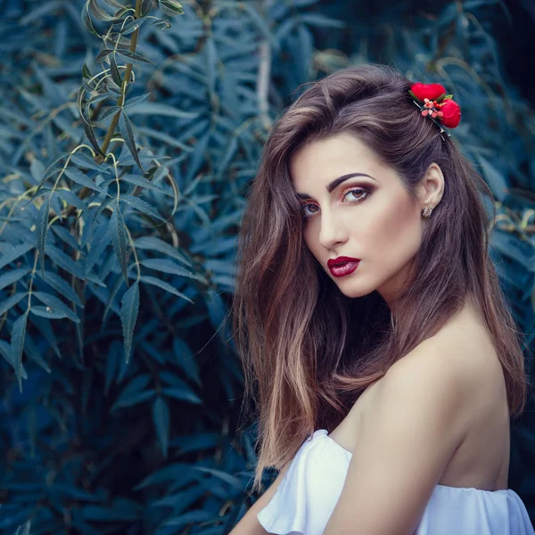 Kvinna med röd blomma i håret — Stockfoto