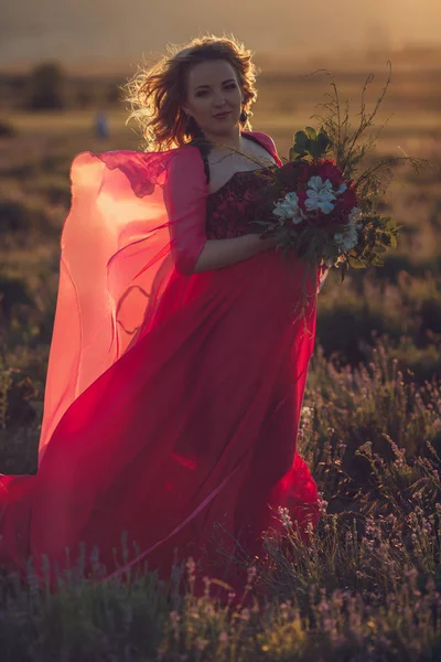 Pregnant woman in holding flowers — Stock Photo, Image