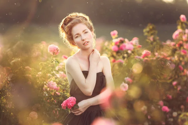 Menina posando perto de rosas rosa — Fotografia de Stock