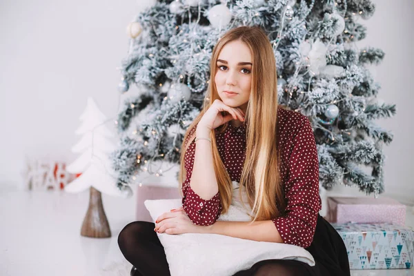 Ragazza seduta vicino all'albero di Natale — Foto Stock