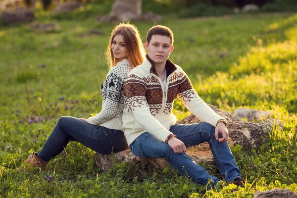 Paret sitter på sten i parken — Stockfoto