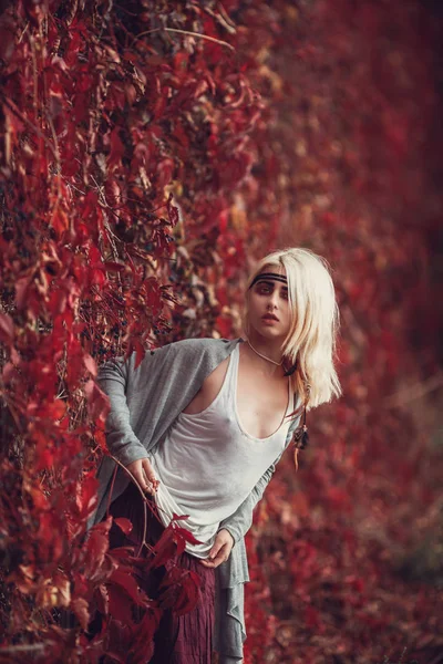Ξανθιά κοπέλα ποζάρει στα κόκκινα φύλλα — Φωτογραφία Αρχείου