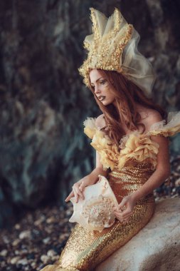 kayanın üzerinde oturan deniz kızı