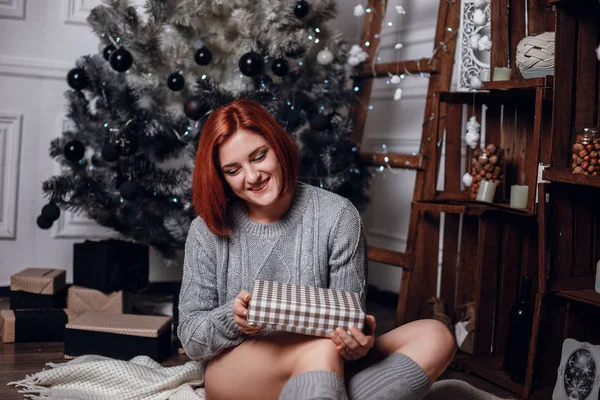 Mujer sentada junto al árbol de Navidad — Foto de Stock